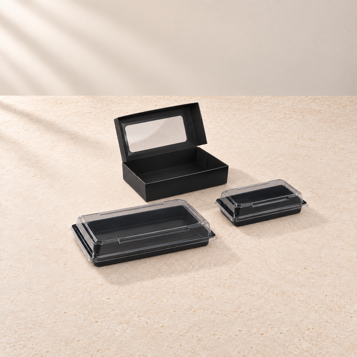 Schwarze Sushi-Trays mit transparentem Deckel und schwarze Faltbox mit Sichtfenster