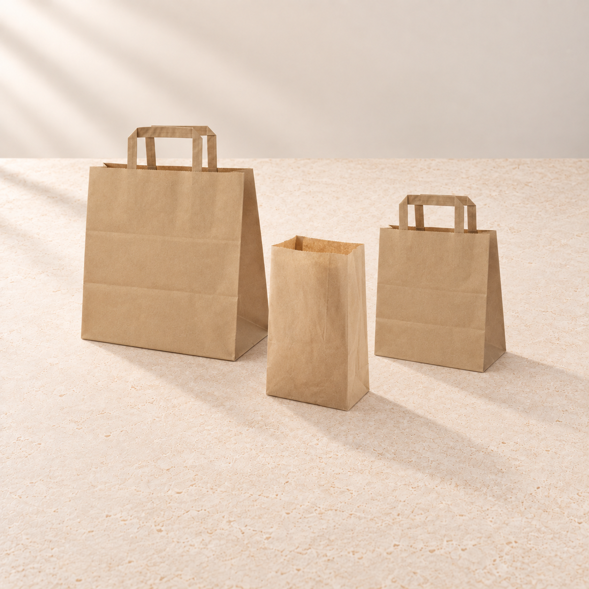 Papiertragetaschen mit Flachhenkel in zwei Größen und Blockbodenbeutel